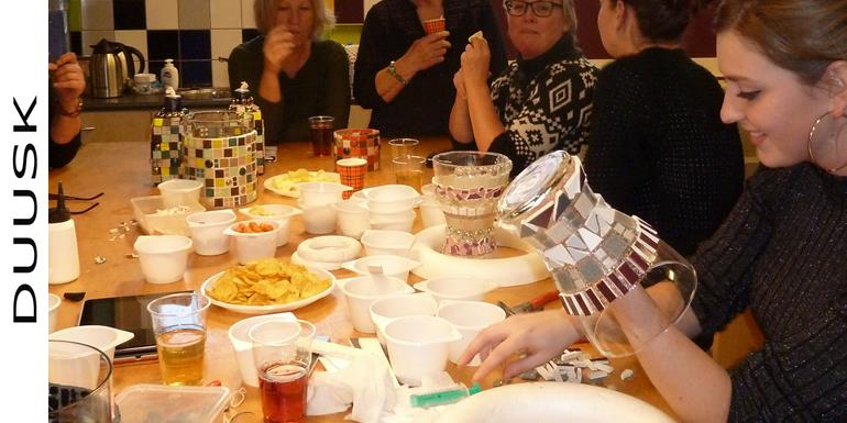 Vrijgezellenfeest in Drenthe vlak bij Emmen, aan grote tavel word de mozaiek workshop gemaakt. Er staan Chips en Nootjes op de tafel.